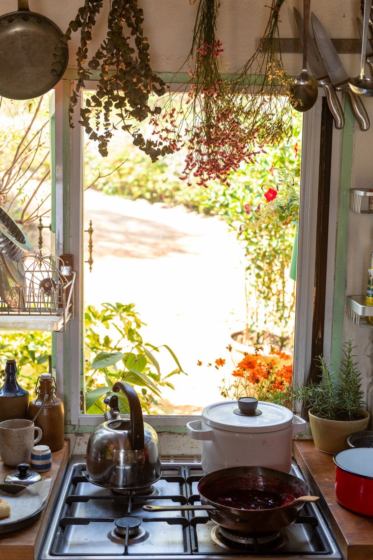 Cuisine ouverte sur le jardin fleuri, confiture qui mijote sur le feu